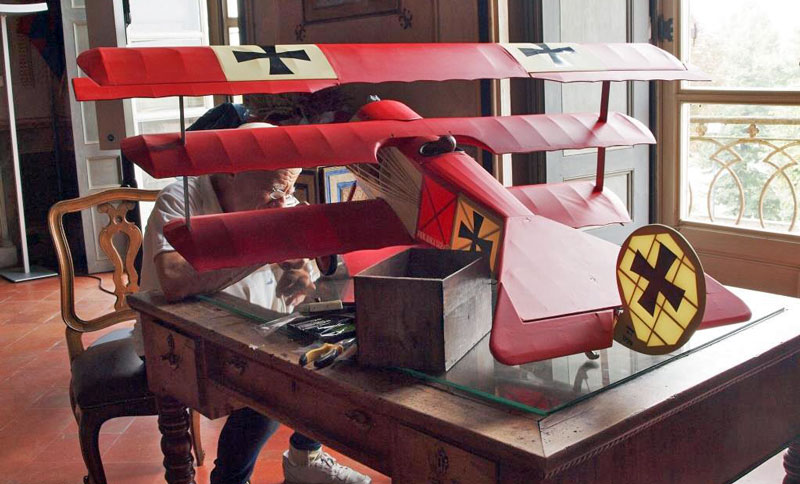 Figura 7 - Olimpio, fratello di Andrea Ferrero è un bravissimo modellista aeronautico; in questa fotografia lo vediamo alle prese con un piccolo lavoro di sistemazione del notissimo triplano Fokker Dr.1 di Manfred von Richthofen : il mitico “Barone Rosso”. L’aereo è ovviamente stato interamente costruito da Olimpio.