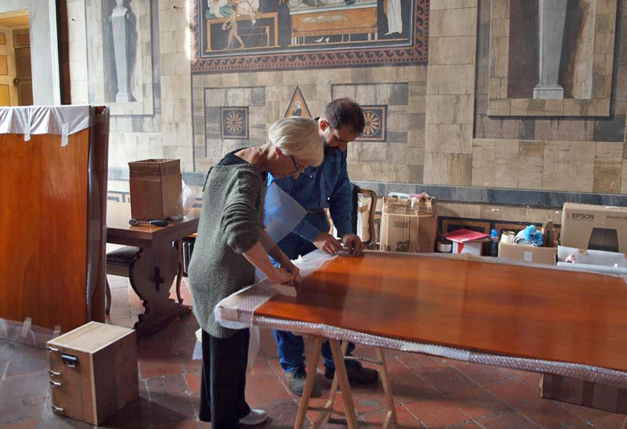 Figura 9 - Le prime operazioni di montaggio per l’allestimento della mostra; Antonella Corno e il sottoscritto liberano i tabelloni di legno dagli imballi. I tabelloni ospiteranno circa il 25% della documentazione storico-cartacea della prestigiosa fabbrica di organi a canne “Fratelli Aletti” di Monza.