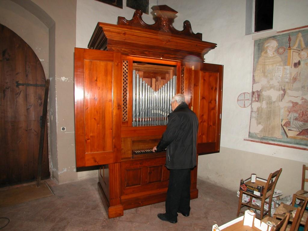 Don Mario Conconi osserva il suo organo perfettamente restaurato nei più piccoli particolari.